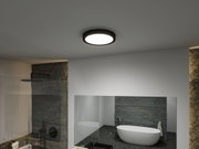 Round ceiling light with black frame and white illumination in modern bathroom with bathtub.