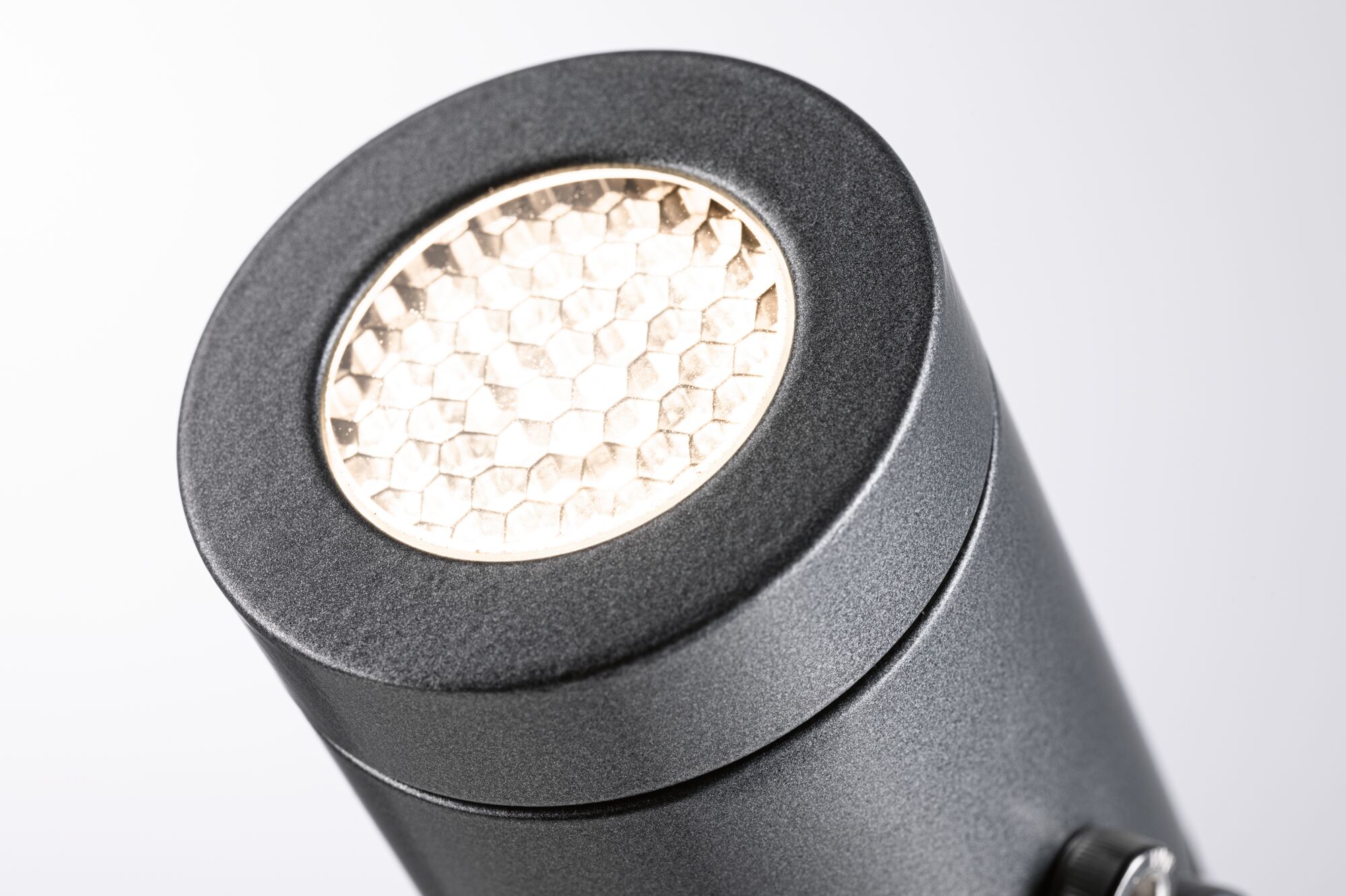 Close-up of black aluminum LED spotlight with honeycomb diffuser for accent lighting in interiors