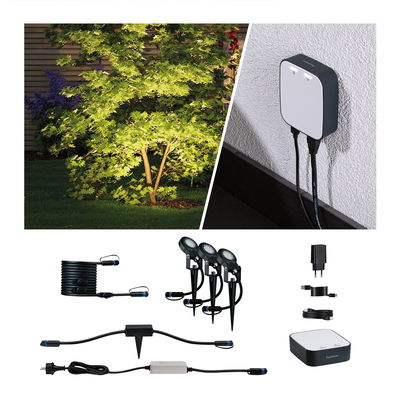 Kit d'éclairage extérieur avec trois spots LED noirs, câbles et unité de contrôle pour jardin.
