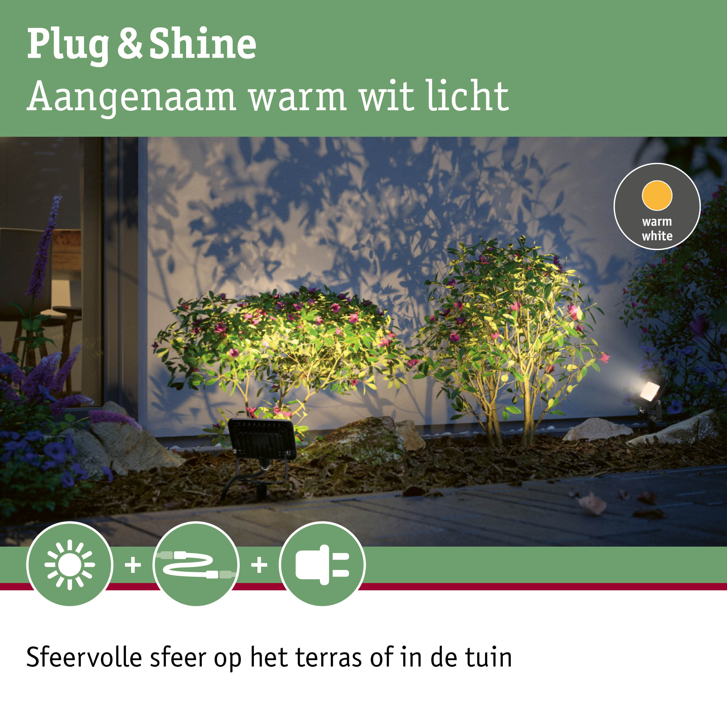 Buitenstraalspot met warm wit licht verlicht groene planten bij huismuur in tuin