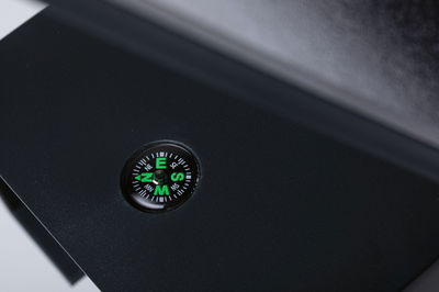 Petit compas vert dans un boîtier noir sur surface noire mate pour une orientation précise