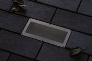 Rechthoekige roestvrijstalen vloerverlichting met gaas op donkere bestrating voor buitenverlichting