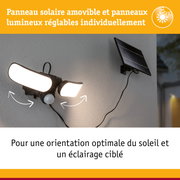 Lampe solaire noire avec panneaux LED réglables et panneau solaire fixée sur mur gris extérieur
