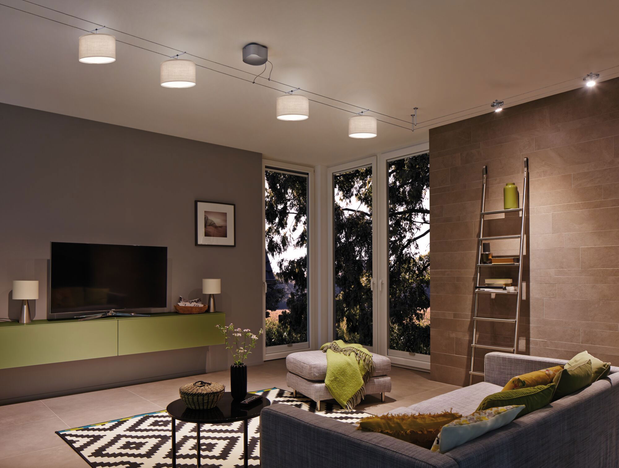 Salon moderne avec canapé gris, buffet vert et suspension avec abat-jours en tissu