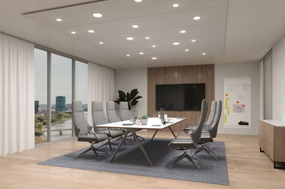 Modernes Konferenzzimmer mit grauen Stühlen, weißem Tisch und LED-Deckenleuchten für Bürobeleuchtung
