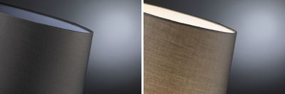 Nahaufnahme eines grauen Stofflampenschirms mit weichem Licht und modernem Design