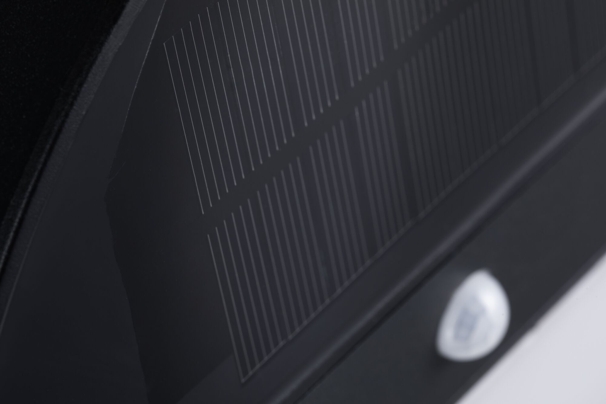 Close-up of black glass ceramic cooktop with fine white lines and control panel visible.