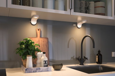 Plan de travail de cuisine moderne avec robinet noir, plateau en marbre et éclairage LED sous meuble.