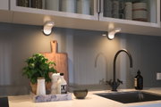 Moderne Küchenarbeitsplatte mit schwarzem Wasserhahn, Marmor-Tablett und LED-Unterbauleuchten.