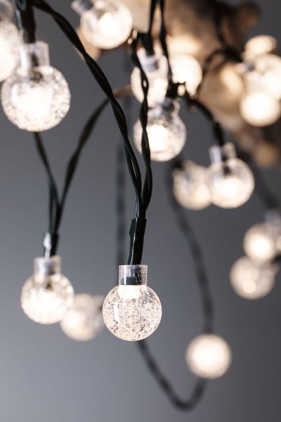 LED string lights with clear globe bulbs and black wires for atmospheric decoration.