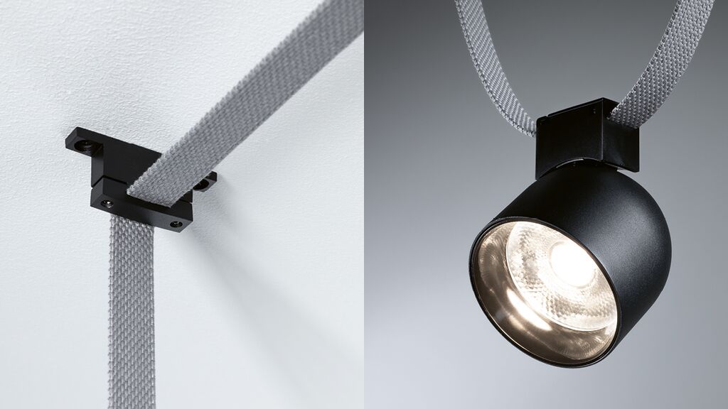 Montage ULine an Decke Zwarte metalen LED-spot met grijze stoffen kabel gemonteerd aan wit plafond, moderne verlichting