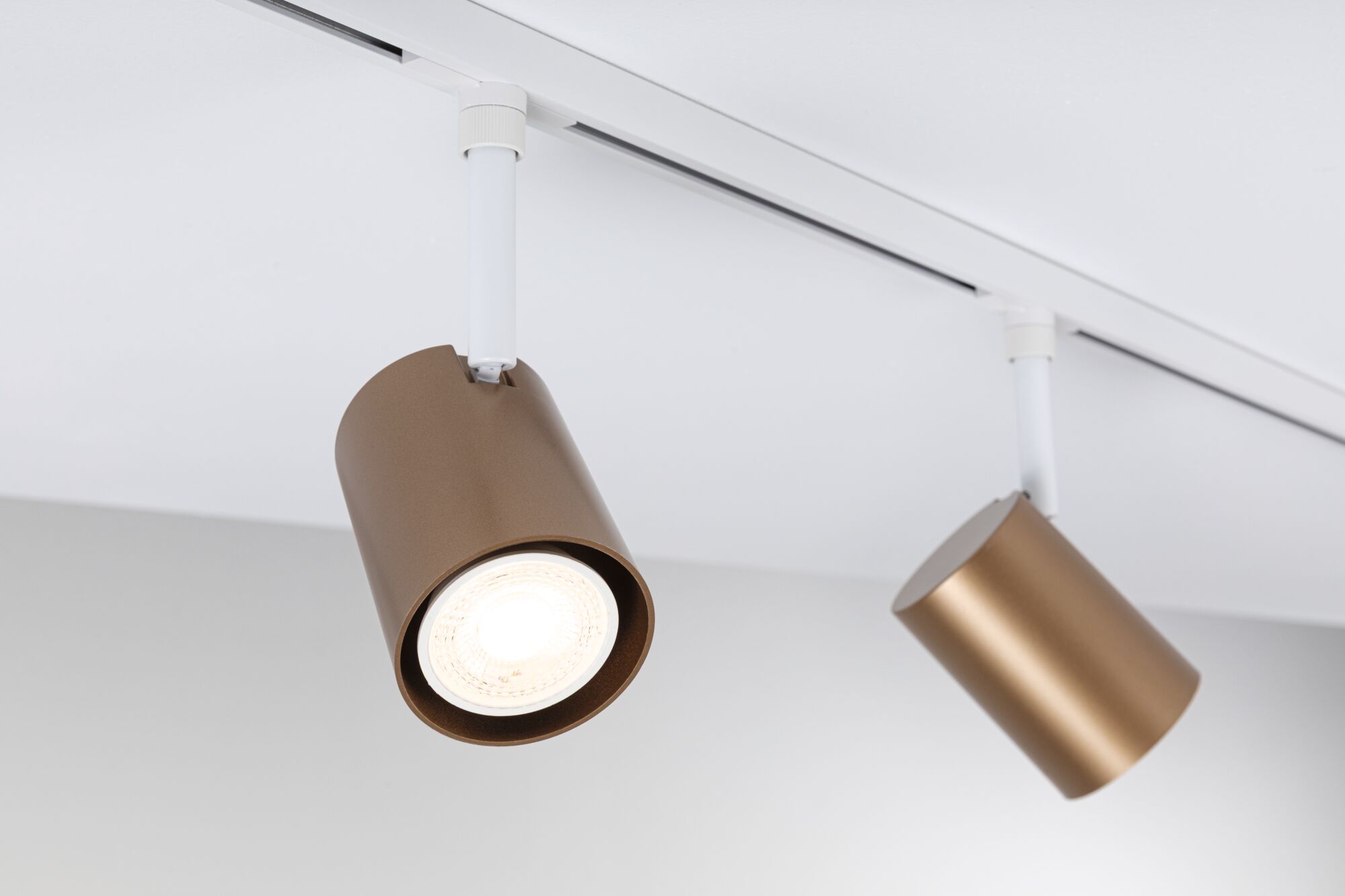 Deux spots en aluminium marron sur rail blanc pour éclairage LED moderne au plafond