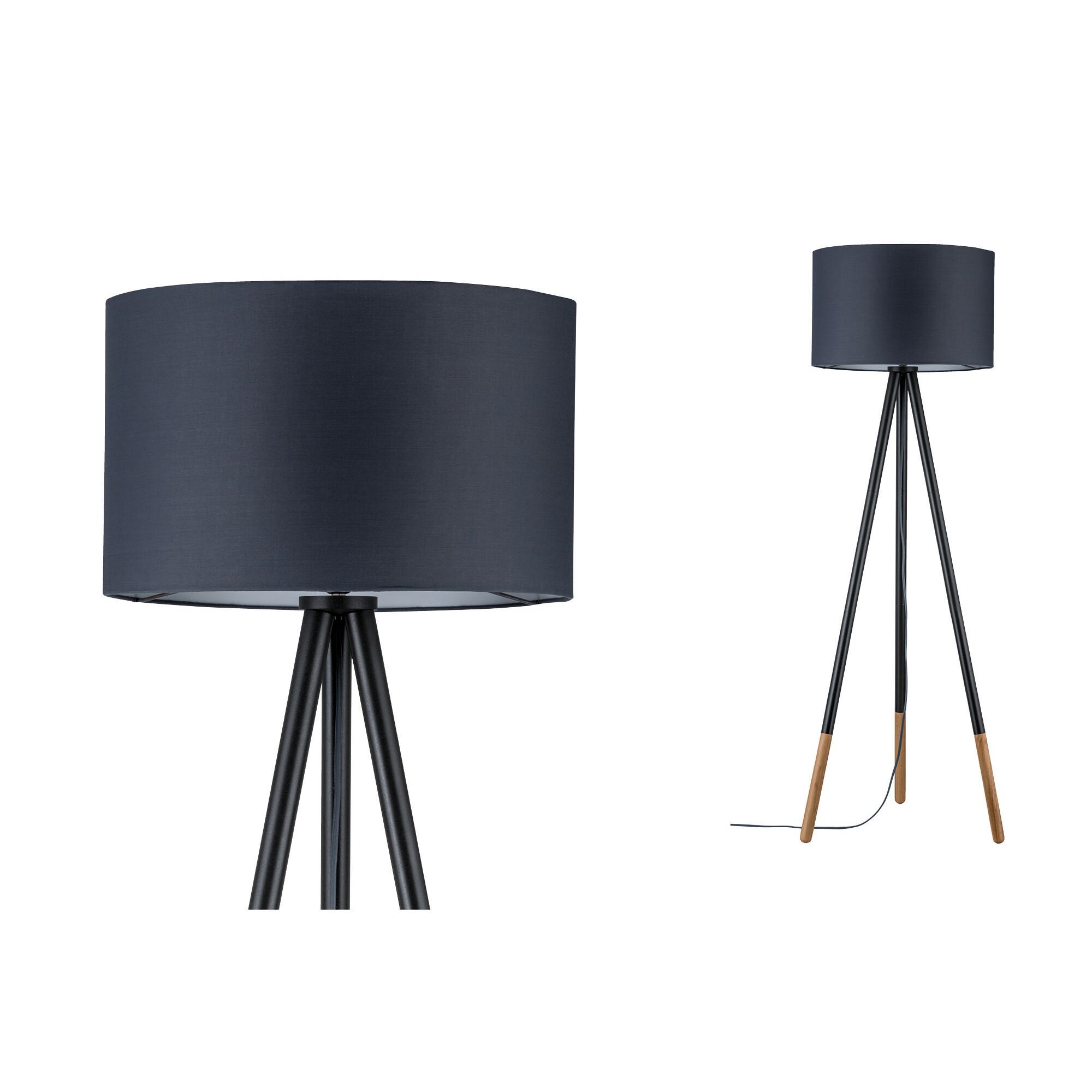 Staande driepootlamp met zwarte stoffen kap en houten poten voor sfeervolle woonkamerverlichting.