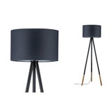 Staande driepootlamp met zwarte stoffen kap en houten poten voor sfeervolle woonkamerverlichting.