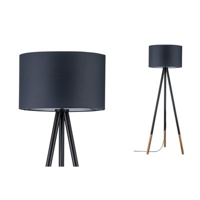 Staande driepootlamp met zwarte stoffen kap en houten poten voor sfeervolle woonkamerverlichting.