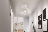 Modern white ceiling spotlight with four adjustable lamps in bright hallway with window and wall decor