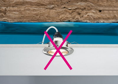 Einbauleuchte mit rotem Kreuz markiert, Installation in Decke mit Dämmmaterial und blauer Folie nicht erlaubt