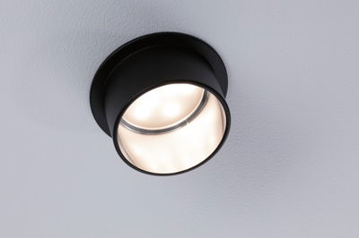 Zwarte ronde LED-plafondspot van metaal met warm wit licht voor moderne interieurs.