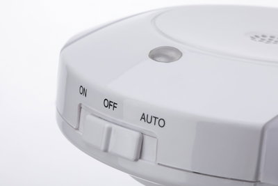 Weißer Kunststoff-Schalter mit den Einstellungen Ein, Aus und Auto für elektronische Geräte.