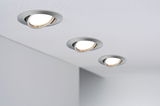 Trois spots encastrés orientables en aluminium brossé installés au plafond pour éclairage moderne