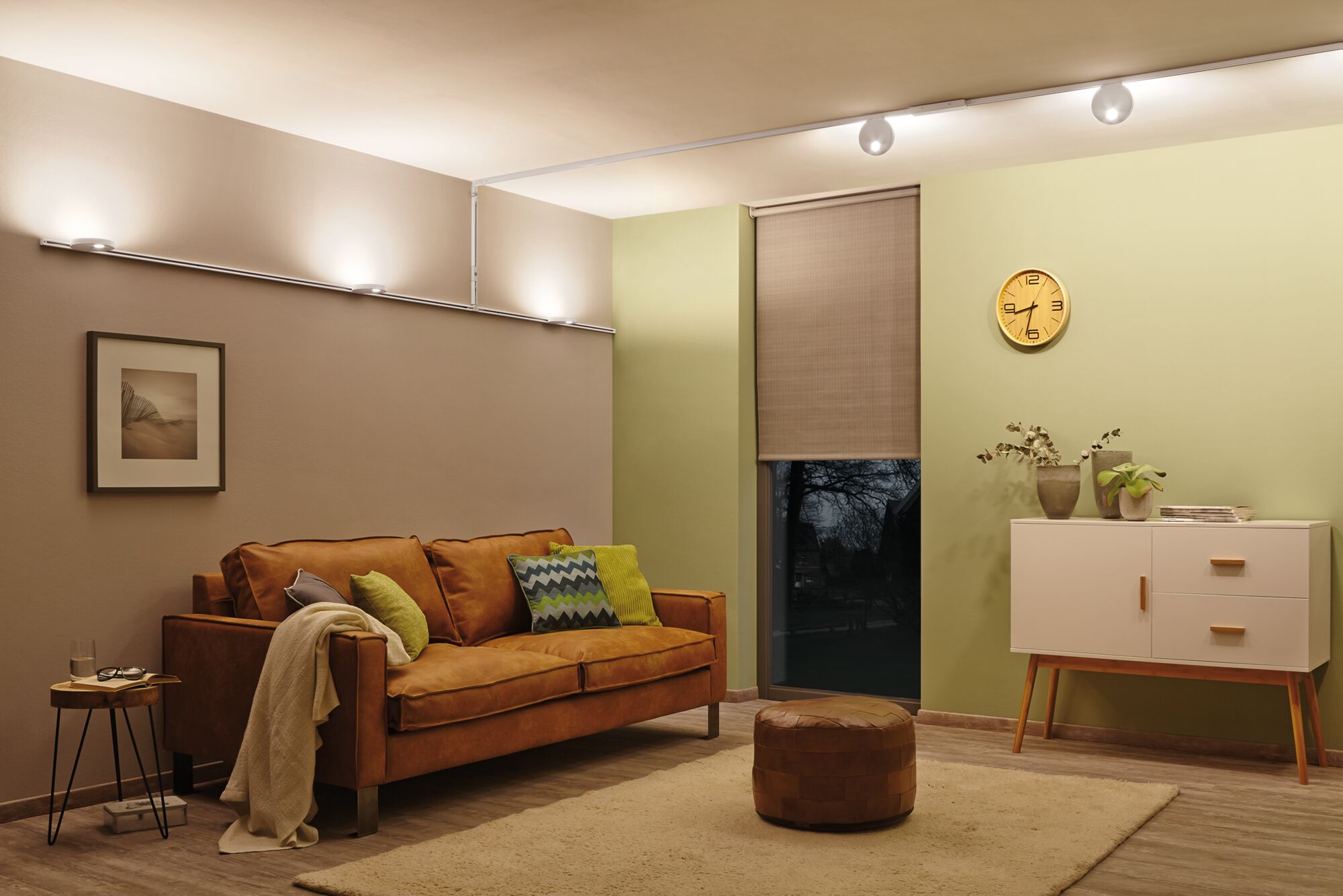 Moderne woonkamer met bruine leren bank, vloerkleed, wit dressoir, verlicht met LED-plafondlampen