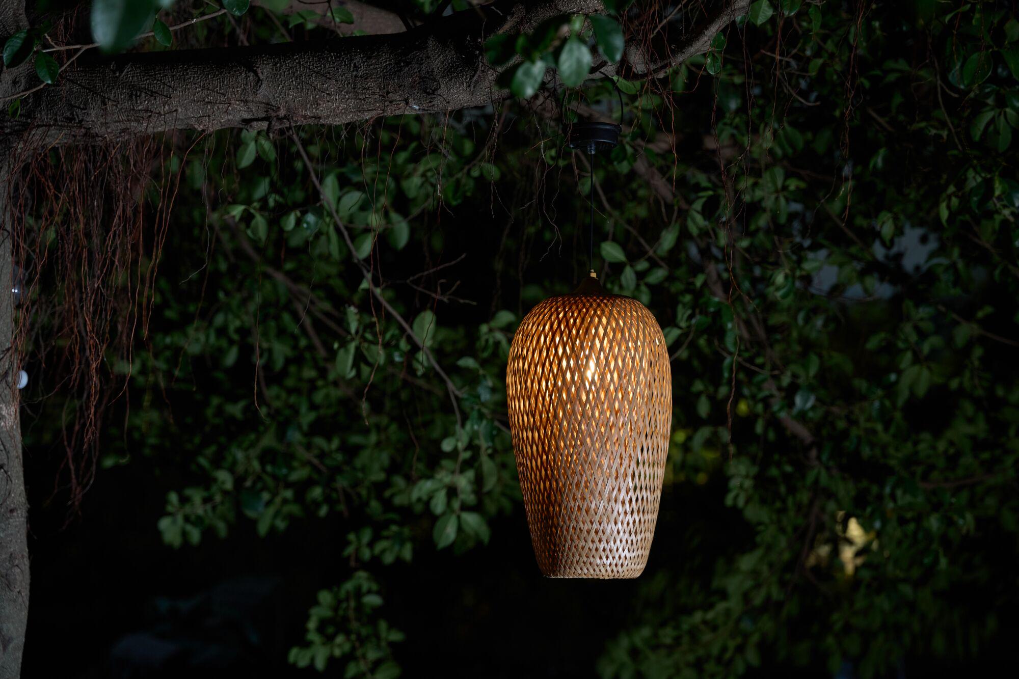 Brown woven wood hanging outdoor lamp with warm light for garden lighting and decor