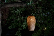 Brown woven wood hanging outdoor lamp with warm light for garden lighting and decor