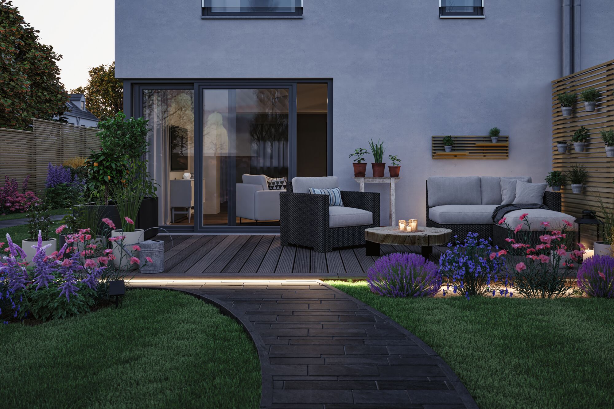 Modern garden with lit pathway, grey polyrattan furniture, and colorful flowers in outdoor living space.