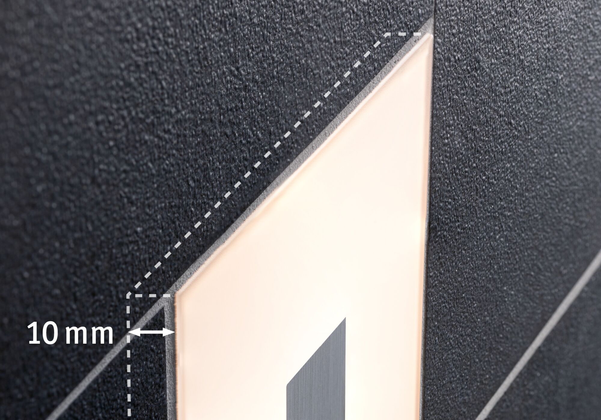 Close-up of black wall with illuminated rectangular LED panel showing 10 mm gap detail.