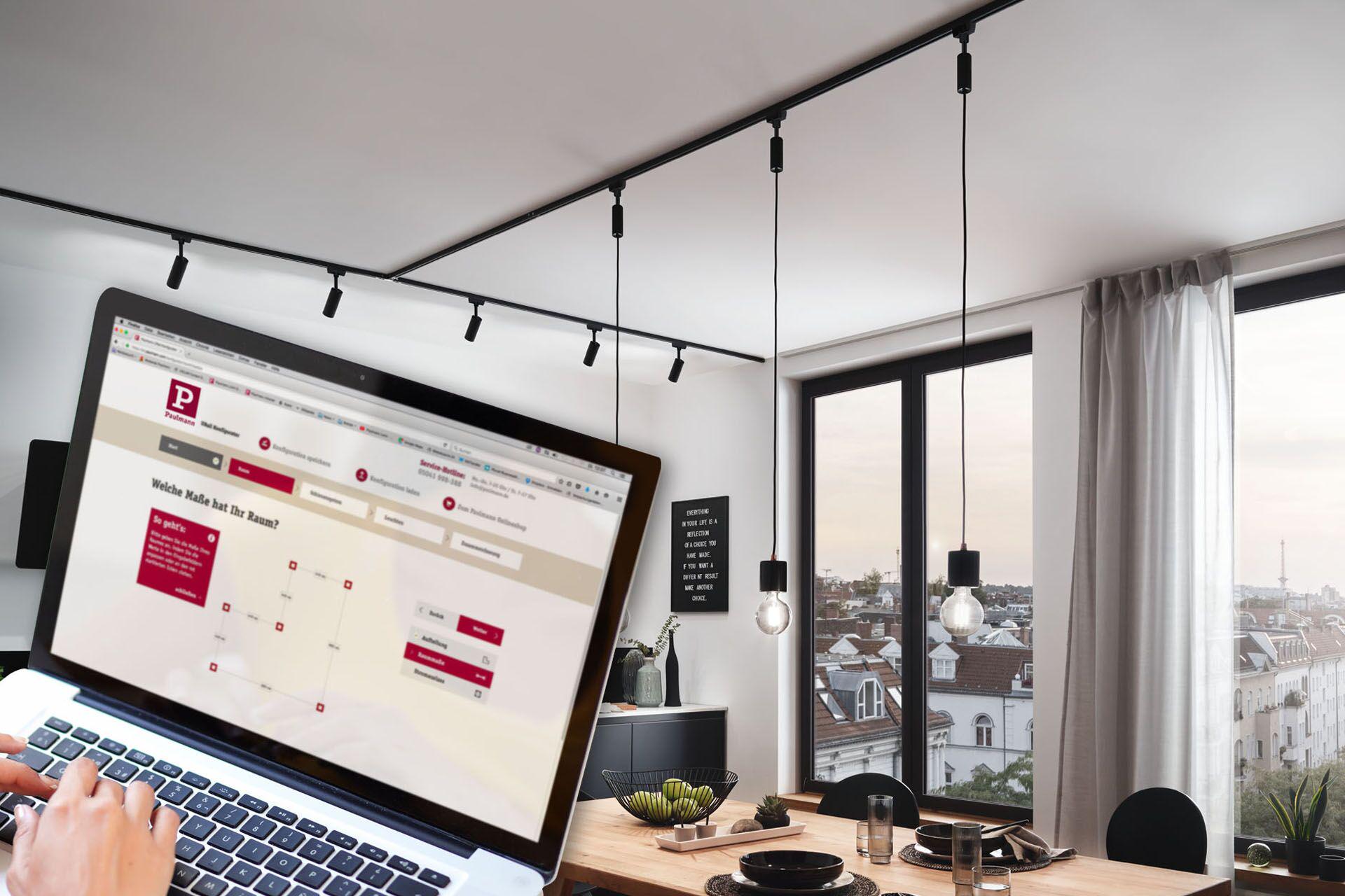 Salle à manger moderne avec système d'éclairage sur rail Urail noir et suspensions en métal, lumière naturelle.