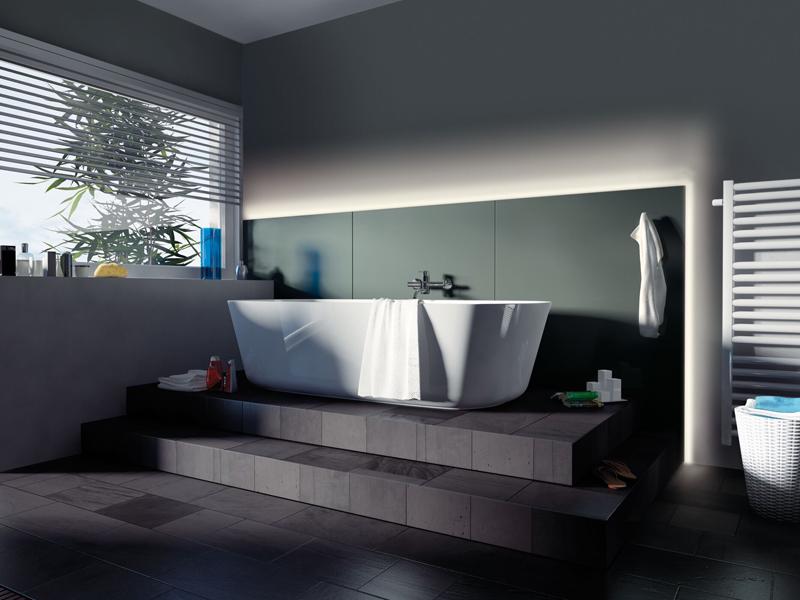 Moderne badkamer met vrijstaand wit bad op donker podium en indirecte LED-verlichting