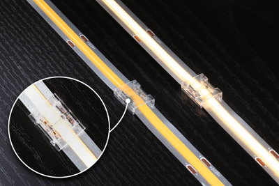 LED-lysskinne med gennemsigtig forbindelse på sort træoverflade, varmt hvidt lys, 24V tilslutning