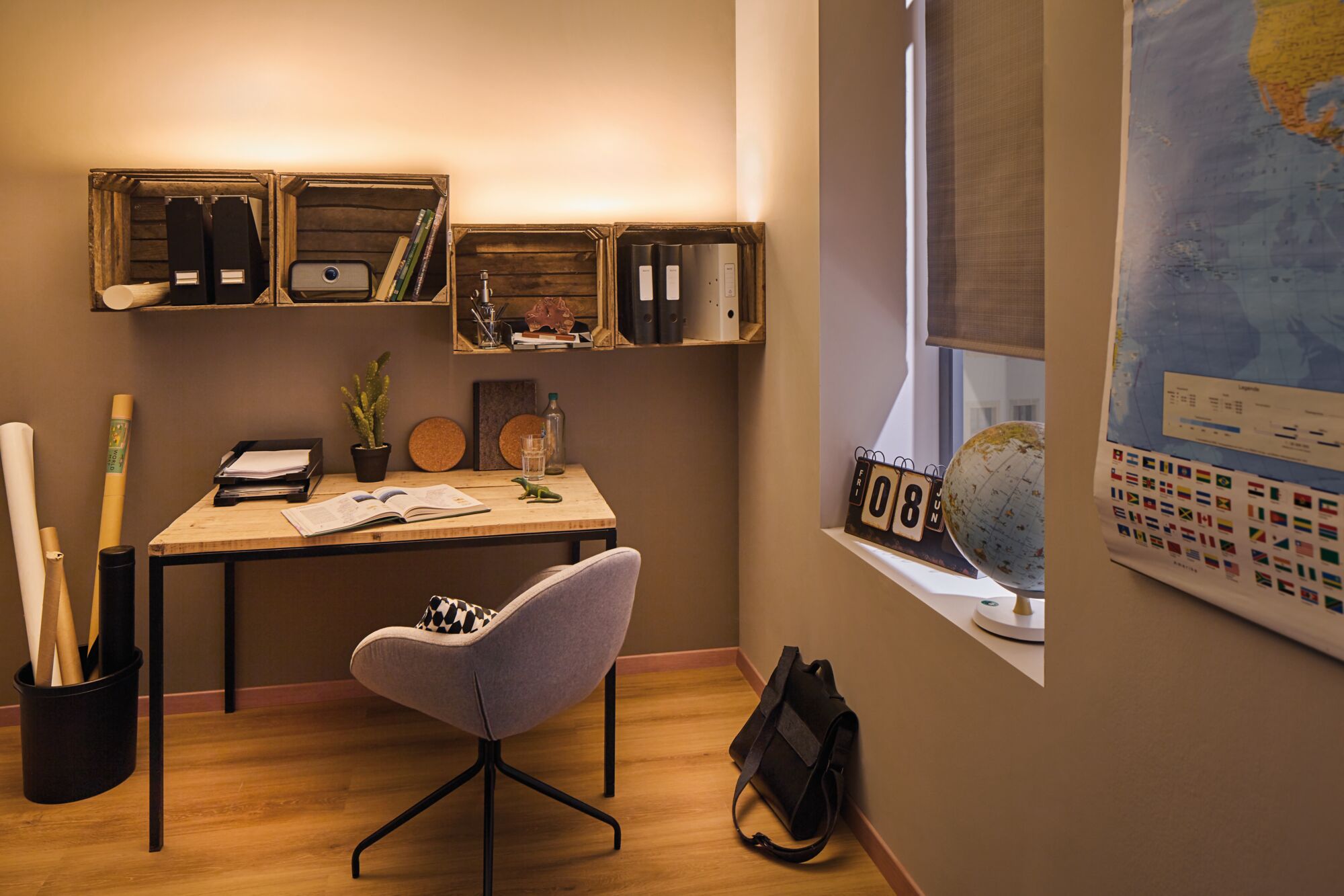 Gezellige werkplek met houten bureau, grijze stoel en warm wit LED-wandlicht voor thuiswerk.