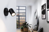Applique murale LED noire en métal avec tête orientable pour un éclairage intérieur moderne.