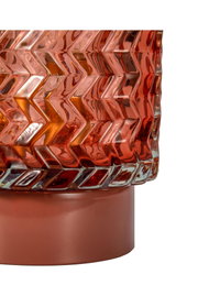 Close-up of red glass lampshade with zigzag pattern and red metal base for home lighting decor