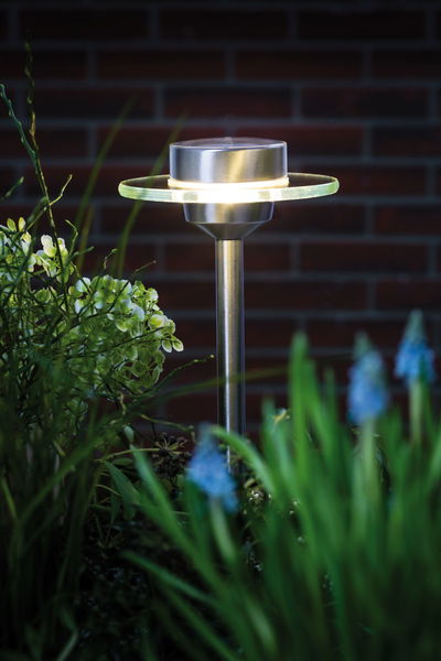 RVS tuinlamp met ronde glazen ring en warm wit LED-licht voor buitengebruik.