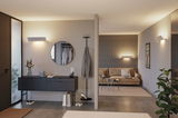 Moderne woonkamer met beige bank, zwarte dressoir en witte wandlampen voor sfeervolle LED-verlichting