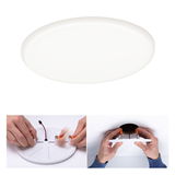 Round white LED ceiling light made of plastic with mounting clips and connection cable for living spaces.