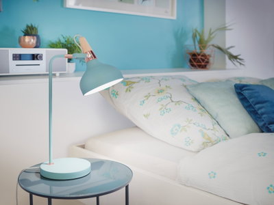 Pastellblaue Tischlampe aus Metall mit Holzgriff auf Glasbeistelltisch neben Bett mit floralem Bettbezug