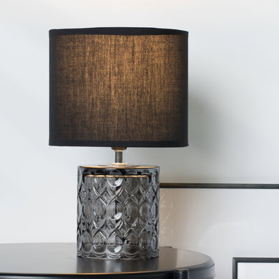 Table lamp with black fabric shade and patterned grey glass base for elegant home lighting