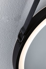 Miroir LED rond noir avec lumière intégrée et sangle de suspension noire sur mur texturé