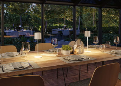 Modern wooden dining table with two white LED table lamps in cozy dining room setting.