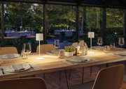 Modern wooden dining table with two white LED table lamps in cozy dining room setting.