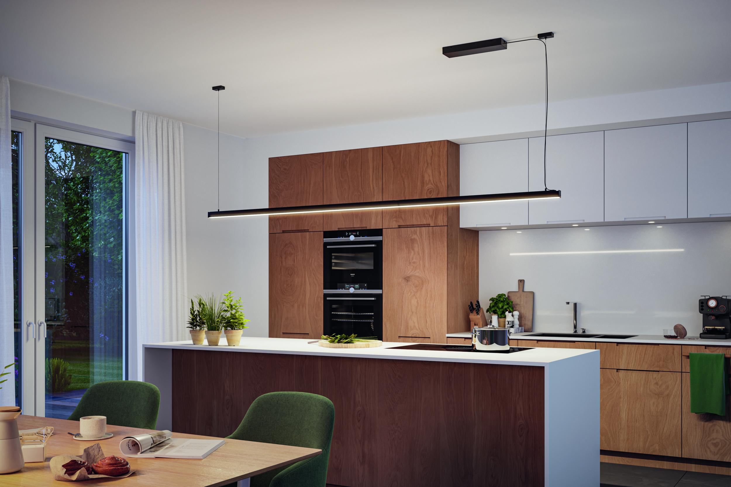 Moderne keuken met houten fronten en wit werkblad, zwarte LED-hanglamp boven kookeiland.