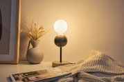 Modern table lamp with wooden base and black metal stem, warm white light, decorative in living room.