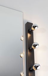 Black wall lamp with three silver bulbs beside mirror, modern LED wall light for bathroom and hallway
