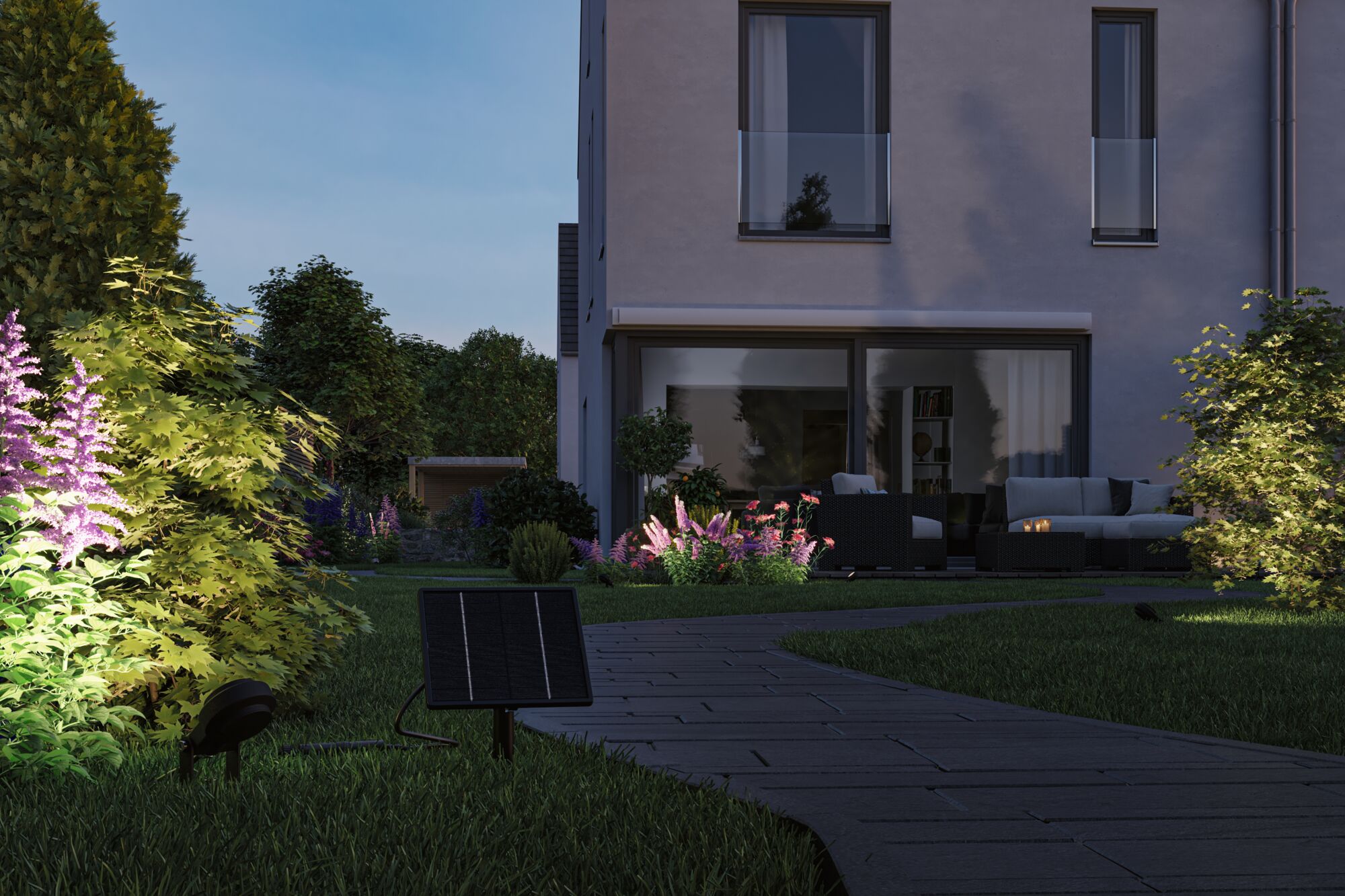 Lanterne solaire de jardin avec panneau solaire noir éclairant une haie verte et un chemin au crépuscule