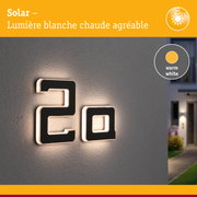 Éclairage solaire avec lumière blanche chaude sur mur, design moderne pour extérieur