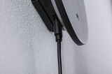 Close-up of black cable connection on grey plastic wall mount with textured surface