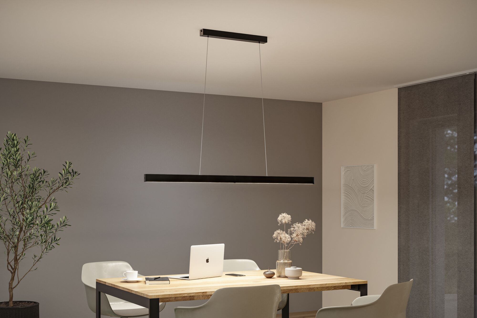 Schwarze LED-Pendelleuchte aus Metall über hellem Holztisch mit Laptop und Deko im Esszimmer.